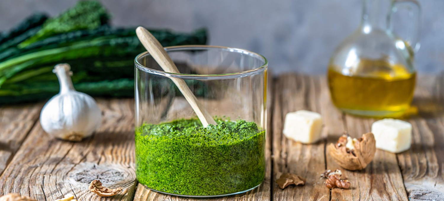 homemade-kale-pesto-served-glass-jar-wooden-surface-with-grey-background-basic-ingredien
